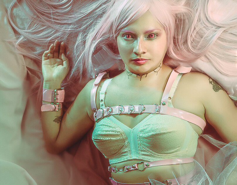 A pink-haired figure reclining in soft pastel-green light.